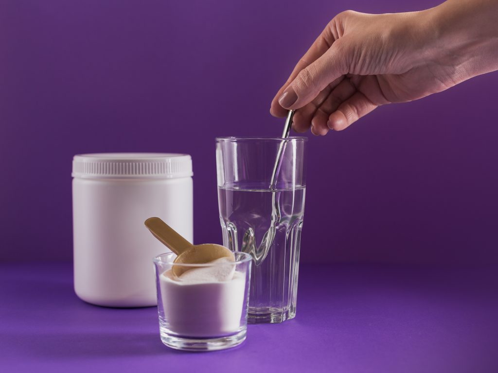 Glass with creatine dissolved in water and collagen protein powder